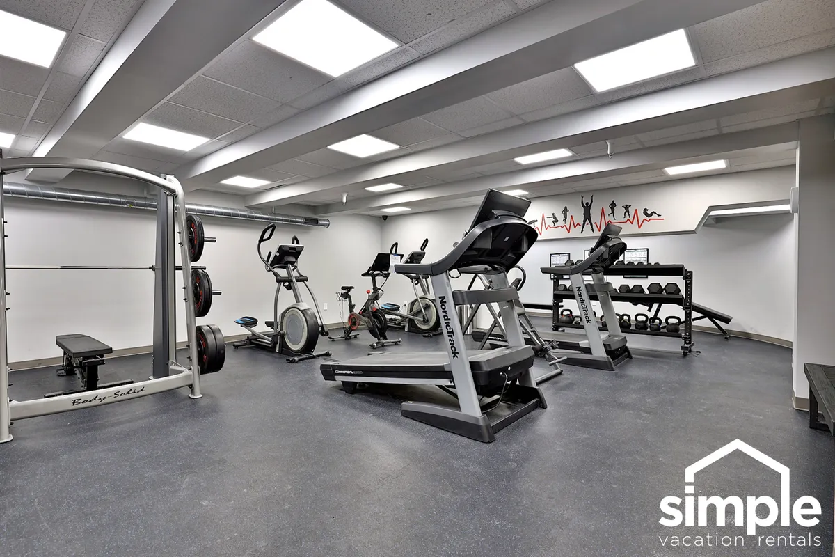 A modern fitness center filled with weight lifting equipment, ellipticals, and exercise bikes. The bright, energetic space is designed to cater to all levels of fitness, supporting wellness routines for couples seeking active and restorative options during their stay.