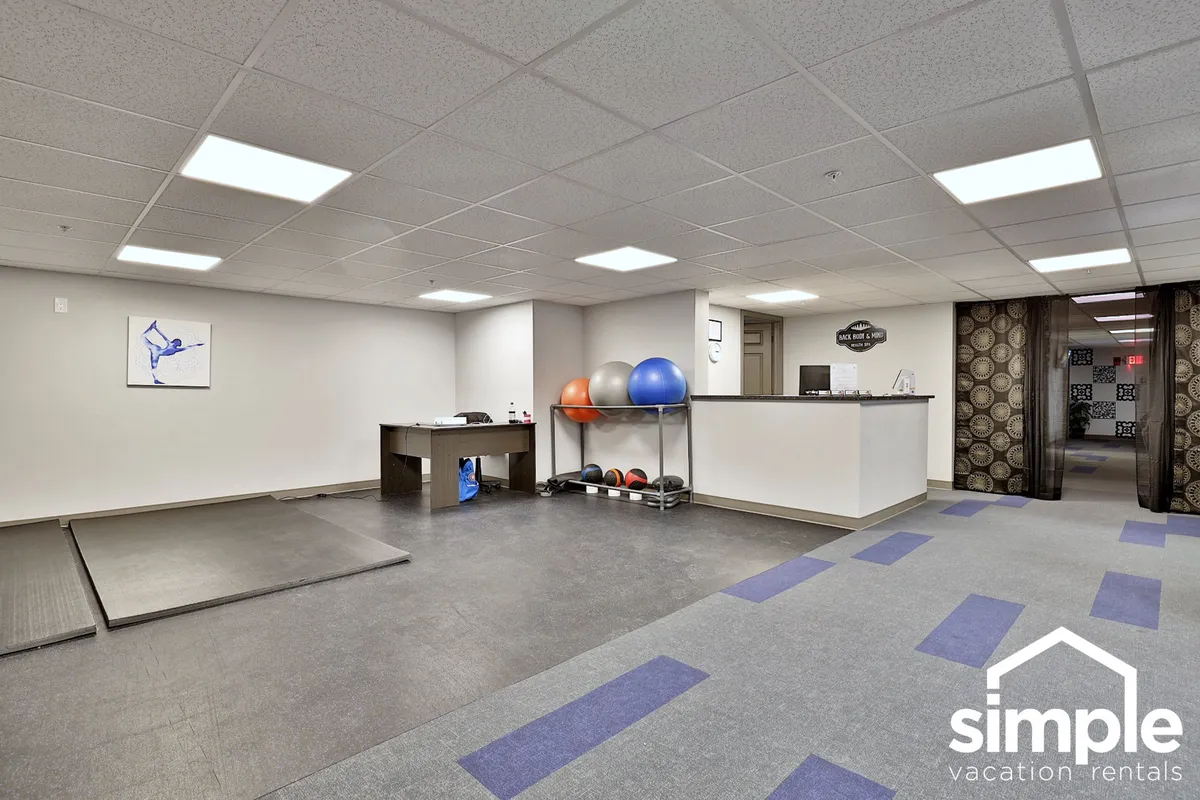 A modern fitness space with exercise mats, fitness balls, and a reception desk. The open area is set up for solo workouts, group classes, or stretching, with a motivating and energetic vibe.