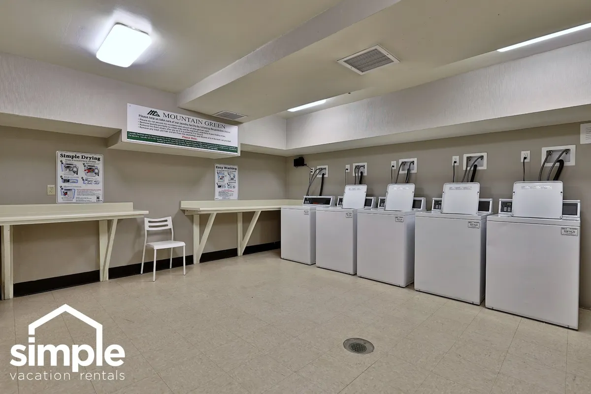 This interior shot shows shared laundry facilities, including washing machines, dryers, and counters for folding clothes. The space is practical and efficient, reflecting the convenience provided for guests during their stay.